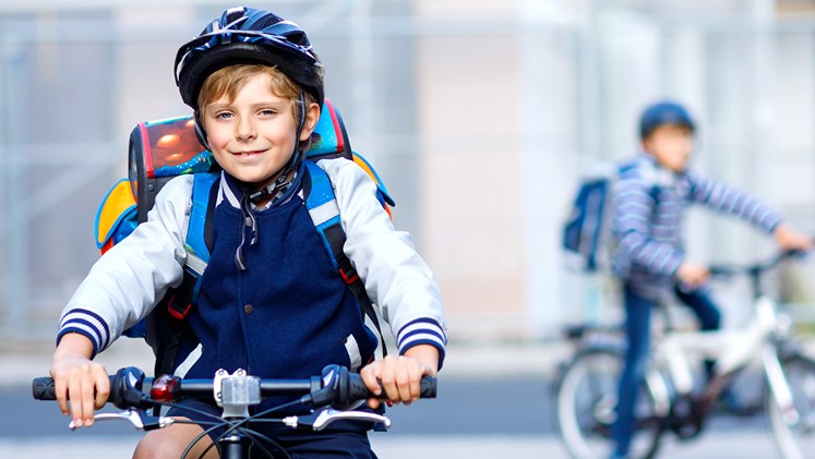 Schuljunge fährt Fahrrad mit Fahrradhelm